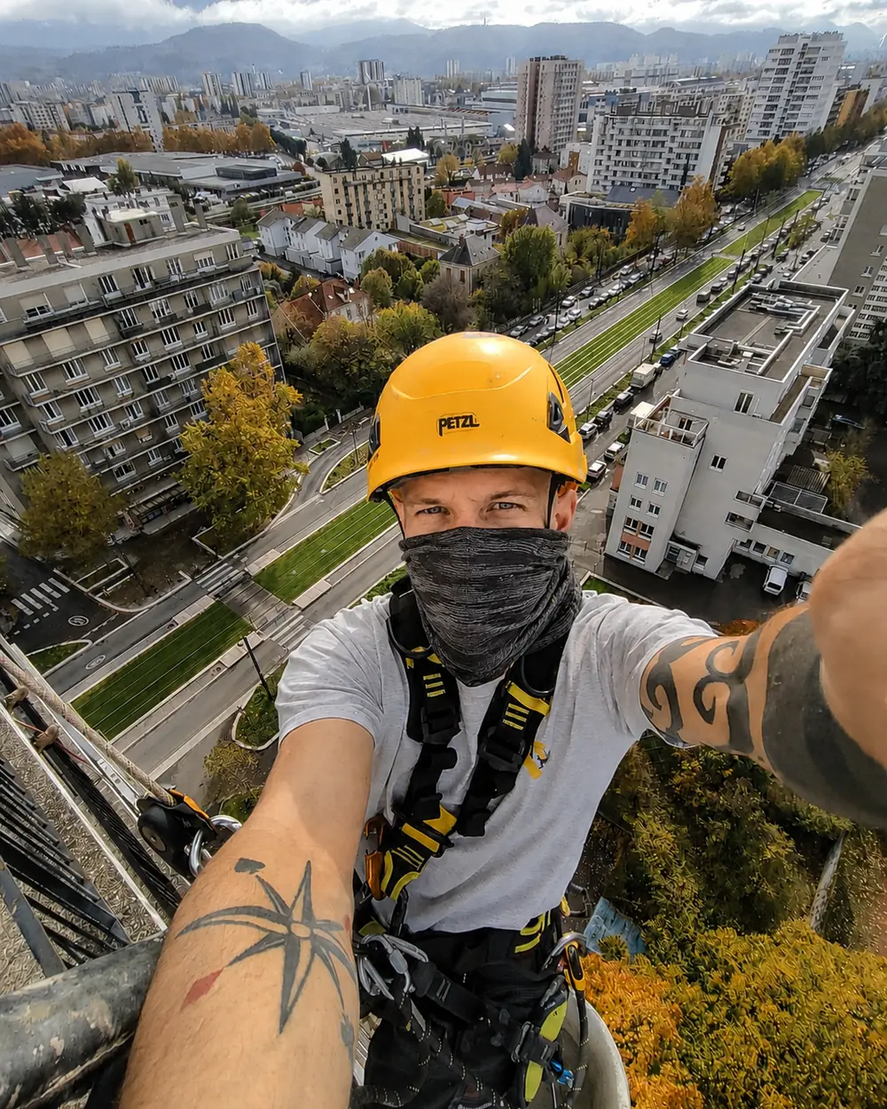 Cordiste Yaniro équipé d'un casque Petzl et d'un harnais, en intervention en hauteur au-dessus de la cuvette grenobloise — travaux d'accès difficile à Grenoble.