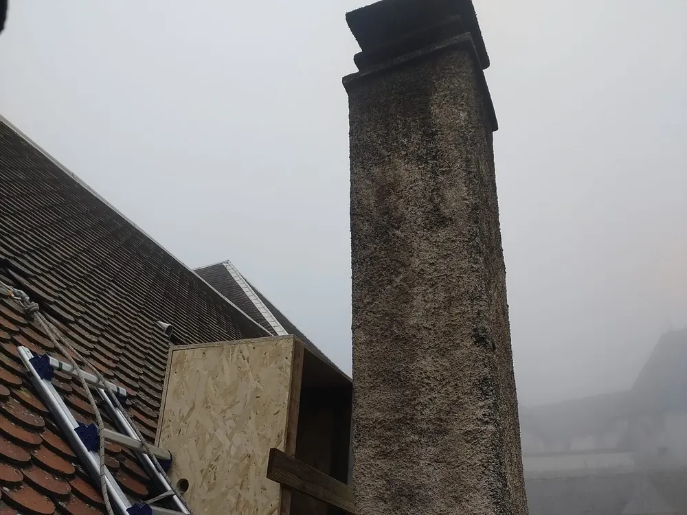 Intervention sur cheminée en pierre vue depuis la toiture — accès cordiste sous brouillard